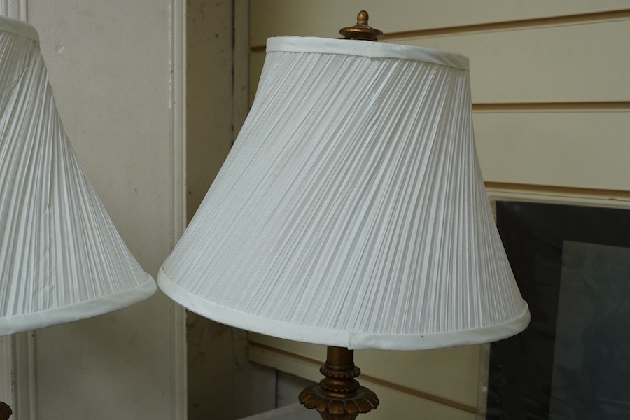 A pair of gilt resin table lamps with white shades, 76cm high. Condition - fair to good.